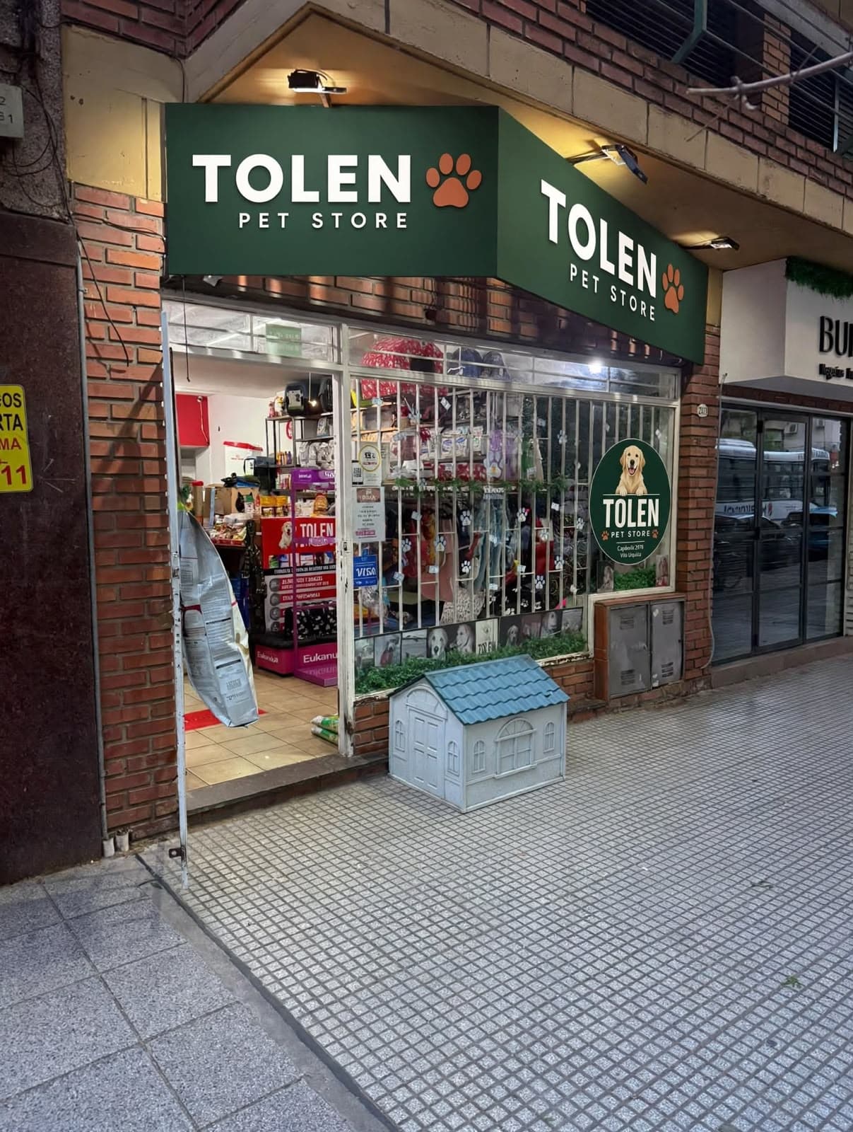 Fachada de Tolen Pet Store, con cartel verde y huella naranja, sobre Capdevila 2978